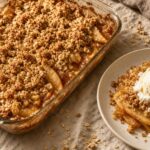 Baked apple crisp with golden oat streusel and bubbling cinnamon apples in a glass pan