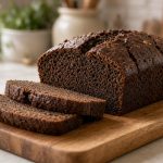 Sliced gingerbread loaf with a dark crumb
