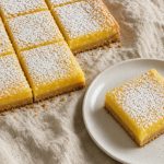 Lemon bars with shortbread crust and bright lemon filling dusted with powdered sugar