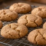 Snickerdoodle cookies coated in cinnamon sugar on a cooling rack